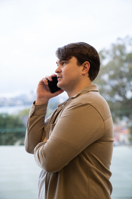 Hayden, founder of Golden Eggs Property, on a phone call with Sydney harbour in the background
